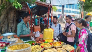 हरिद्वार रेलवे स्टेशन के पास नंदकिशोर की ठेली पर झालमुड़ी खरीदते लोग। जागरण