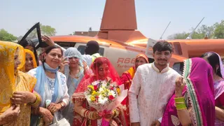 हेलीकॉप्टर से विदा होने के दौरान दूल्हा और दुल्हन।