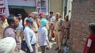 शव की जांच करने के लिए पहुंचे पुलिस अधिकारी लोगों से बातचीत करते हुए।