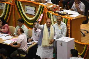 निगम सदन में मेयर पद पर जीत के बाद विक्ट्री का साइन दिखाते प्रवेश वाही।
