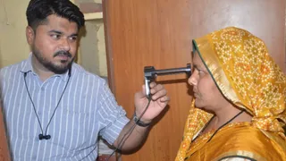 उपनिबंधक कार्यालय में महिला के आंख की पुतली की जांच करता कर्मचारी। जागरण