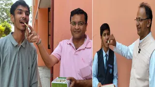 12 वीं के वत्सल गोयल को मिठाई खिलाते पिता व दसवीं परीक्षा के टाॅपर आरव उपाध्याय को मिठाई खिलाते सेंट थामस स्कूल के प्रधानाचार्य। जागरण
