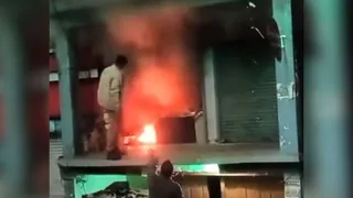 चंबा में गुल्डी रोड़ पर टेलर की दुकान में लगी आग को बुझाते पुलिस कर्मी व दुकान स्वामी।