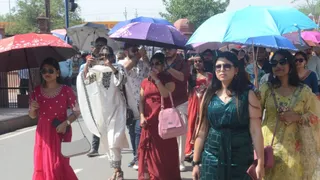 छाता लेकर जाती युवतियां। जागरण