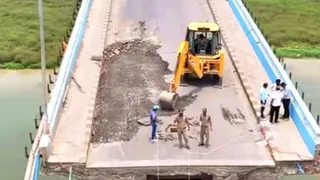विक्रमशिला सेंतु पर बेली ब्रिज निर्माण कार्य के लिए जेवीसी से सड़क पर काम करते हुएI (जागरण)