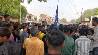 आगरा में नीला झंडा लेकर विरोध करते समाज के लोग।