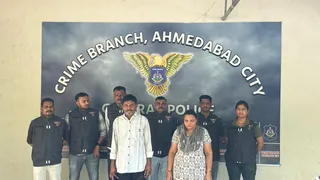 गिरफ्तार दोनों आरोपी और अहमदाबाद सिटी क्राइम ब्रांच की टीम। (सोर्स - X@CrimeAhmedabad)