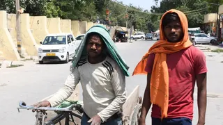 दोपहर की भीषण गर्मी में यमुना बाजार के पास से गुजरते श्रमिक। जागरण