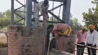 शव को नहर से निकालते हुए गोताखोर।