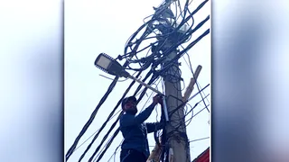 लाइन सही करता बिजली कर्मचारी