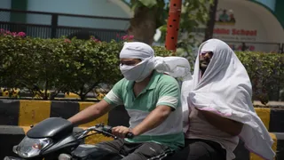 प्रयागराज के सिविल लाइंस में गर्मी से बचने के लिए चेहरे को ढंककर जाते लोग। जागरण