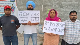 विधायक के घर के बाहर प्रदर्शन कर रहे पूर्व पार्षद व उनका परिवार।