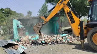 देहरादून के शीशमबाड़ा क्षेत्र में सरकारी भूमि पर बनी अवैध अतिक्रमण मजार को ध्वस्त करती प्रशासन की जेसीबी।