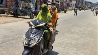 सड़क पर धूप से बचाव के बीच निकलती युवतियां। जागरण