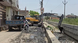 खेकड़ा में गंदे नाले की सफाई करता पालिकाकर्मी। जागरण