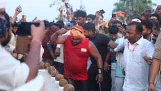 धर्मागतपुर के आदर्श भारतीय इंटर मैदान पर नारियल फोड़ते बाहुबली धर्मेंद्र राजभर लाल टी शर्ट में