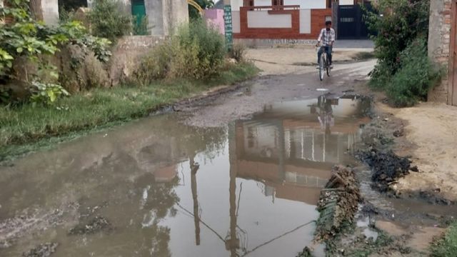 बागपत में मंदिर के पास क्षतिग्रस्त मार्ग पर जलभराव, राहगीरों का गुजरना हुआ मुश्किल; गिरकर घायल हाे रहे वाहन सवार 
