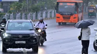दिल्ली में बारिश के बीच गुजरते वाहन चालक। (फाइल फोटो)