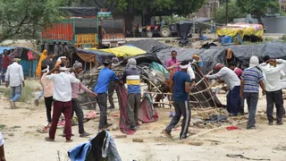 बरौला बाइपास स्थित एडीए की जमीन पर बनी झुग्गियों को हटाते। जागरण।