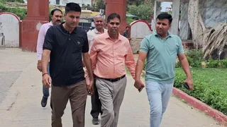 खुर्जा कोतवाली में मंडी सचिव नाहर सिंह (मध्य में) को लेकर आती एंटी करप्शन की टीम। जागरण