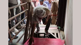 दीक्षित लाइब्रेरी के बेसमेंट में जाने के लिए तहखाने का पट्टा हटाता कर्मचारी। फोटो जागरण