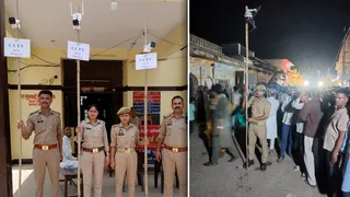 लाठियों पर सीसीटीवी लिए खड़े पुलिसकर्मी