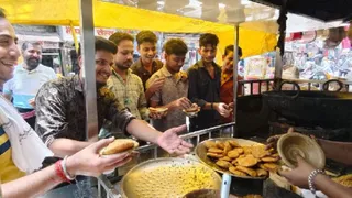फिरोजाबाद के सदर बाजार में कचौड़ी खाते लोग।