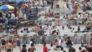 पर्यटक स्थल सहस्त्रधारा में गर्मी से राहत पाने के लिए नहाते पर्यटक। राजेश बड़थ्वाल