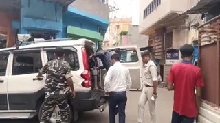 बैंक एजेंटों को पकड़कर गाड़ी में चढ़ाती पुलिस। (फोटो जागरण)