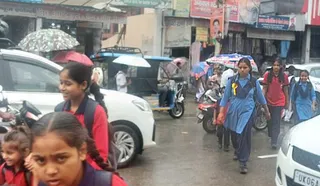 बाजपुर, बुधवार को बारिश के बीच भीगते हुए स्कूल जाते बच्चे। जागरण