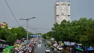 बृहस्पतिवार को सुबह आसमान में छाये काले बादल और हो रही रिमझिम वर्षा में विकास मार्ग पर गुजरते वाहन। चंद्र प्रकाश मिश्र