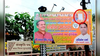 सर्किट हाउस के बाहर लगी होर्डिंग पर जिला प्रभारी व प्रदेश उपाध्यक्ष राजेश यादव के फोटो पर चस्पा सफेद कागज। जागरण
