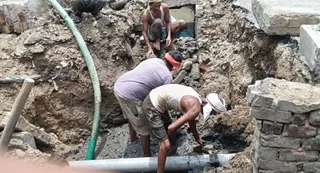 टूटी पाइपलाइन को ठीक करते लोग। जागरण