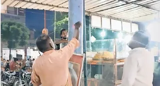 पीपीगंज में टिनशेड से घिरे पोल में करंट की जांच करते बिजलीकर्मी। -जागरण