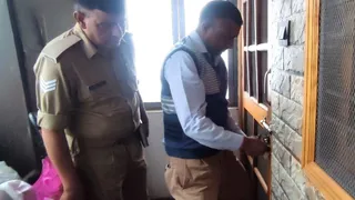मैसानिक लाज स्थित बस स्टैंड में बनाए गए आवास को सील करते एमडीडीए कर्मचारी।