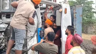 केबिन में फंसे चालक को निकालने का प्रयास करते हुए एसएसएफ की टीम व लोग।