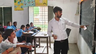 त्रैमासिक परीक्षा के दौरान उत्क्रमित मध्य विद्यालय संडौर के 8 वीं कक्षा में मोबाइल से ब्लैक बोर्ड पर प्रश्नपत्र उतारते शिक्षक