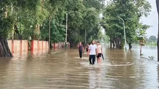 रुड़की में ढंडेरा फाटक के समीप वर्षा के कारण हुए भारी जलभराव के बीच से होकर जाते युवक। जागरण