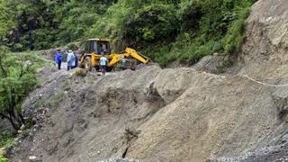 सहस्त्रधारा के पास बारिश में सड़क का एक हिस्सा बह जाने के बाद मरम्मत का काम किया जा रहा हैं। PTI