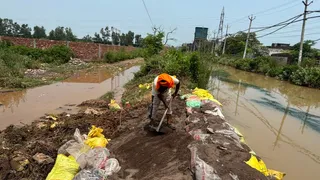 रिहायशी इलाके में घुसे पानी को रोकने का प्रयास करते हुए।