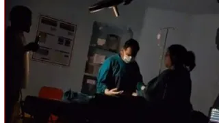 मोबाइल टाॅर्च की रोशनी में आपरेशन करते हुए डाॅक्टर।
