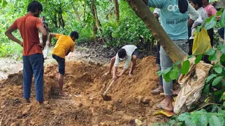 हसनगंज गांव में आरिफ का शव निकालने के लिए क्रब की खुदाई करते श्रमिक।