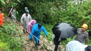 रस्सियों की सहायता से स्यानाचट्टी में यात्रियों को रास्ता पार कराते एसडीआरएफ के जवान। जागरण