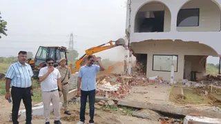 अलीगढ़ के टप्पल क्षेत्र में अवैध निर्माण को गिराता बुलडोजर मौके पर मौजूद प्राधिकरण के अधिकारी। सौ- यीडा