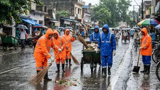 सफाई कार्य के लिए कर्मचारियों को मिली रेनकोट। AI जेनरेटेड फोटो