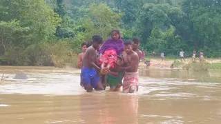 गर्भवती को अस्पताल पहुंचाने के लिए कंधे पर उठाकर नदी पार कराते ग्रामीण। (जागरण)