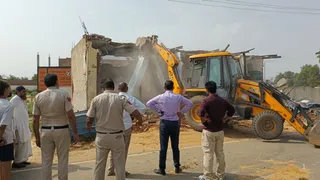 फोटो : नगर के बावला चौक बाईपास पर चलता जिला नगर योजनाकार विभाग का पीला पंजा। जागरण