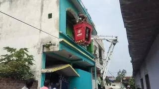 पूछताछ के लिए अरोपित के घर में क्रेन की मदद से घुसने का प्रयास करते पुलिस कर्मी। (जागरण)