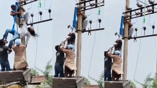 घायल लाइनमैन को नीचे उतारते हुए कर्मचारी।