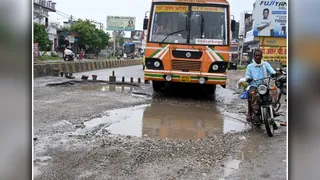 लाल फाटक से रामगंगा रोड पर टूटी सड़क से निकलता ट्रक। जागरण